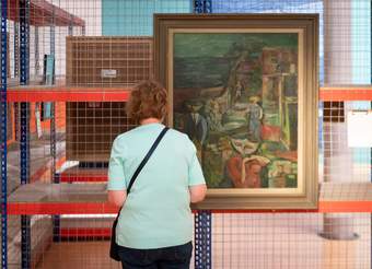 A photograph of a visitor looking at an artwork in the Ideas Depot display at Tate Liverpool